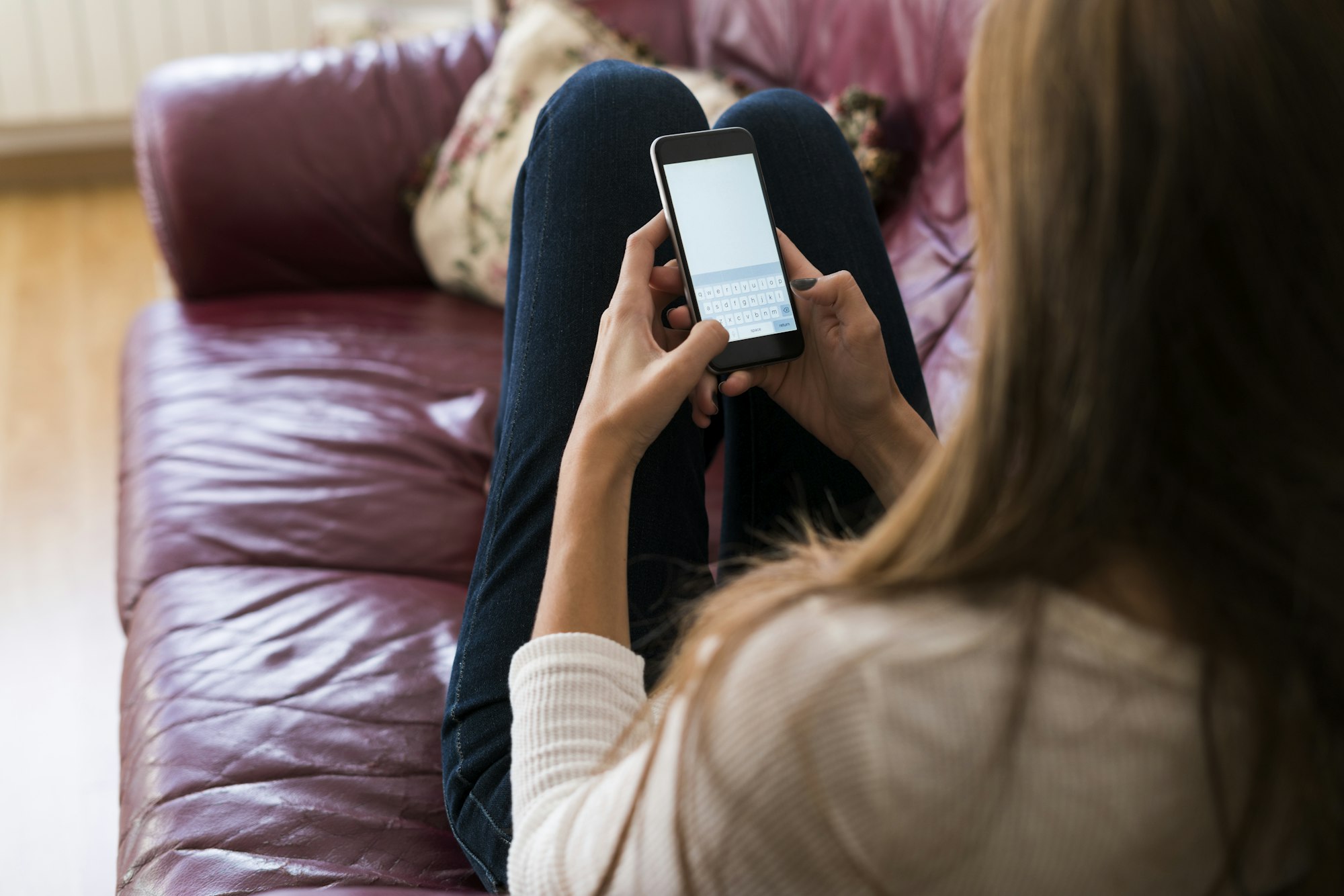 Young woman on couch text messaging