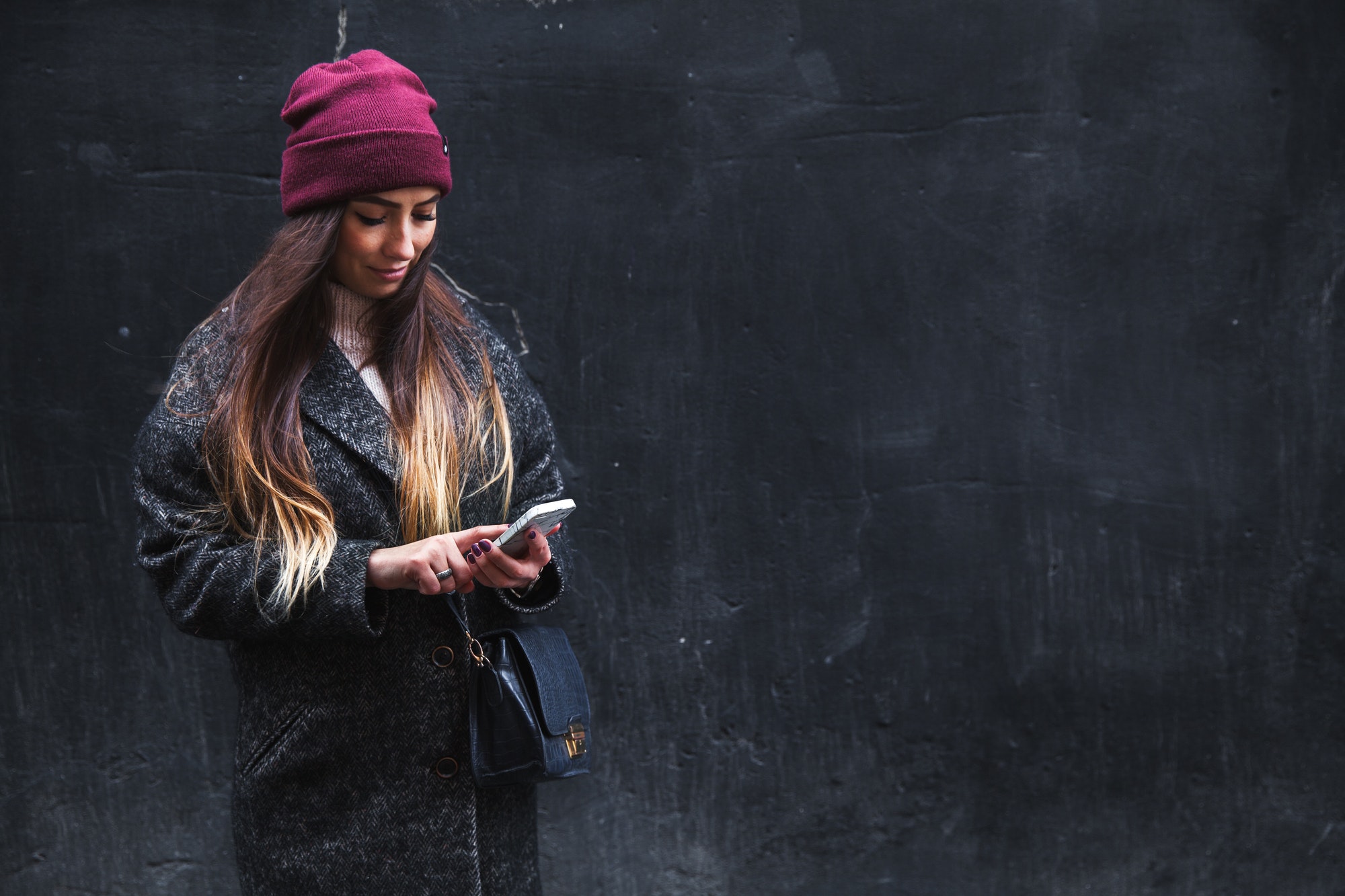 Happy beautiful woman enjoys on mobile phone on a black background