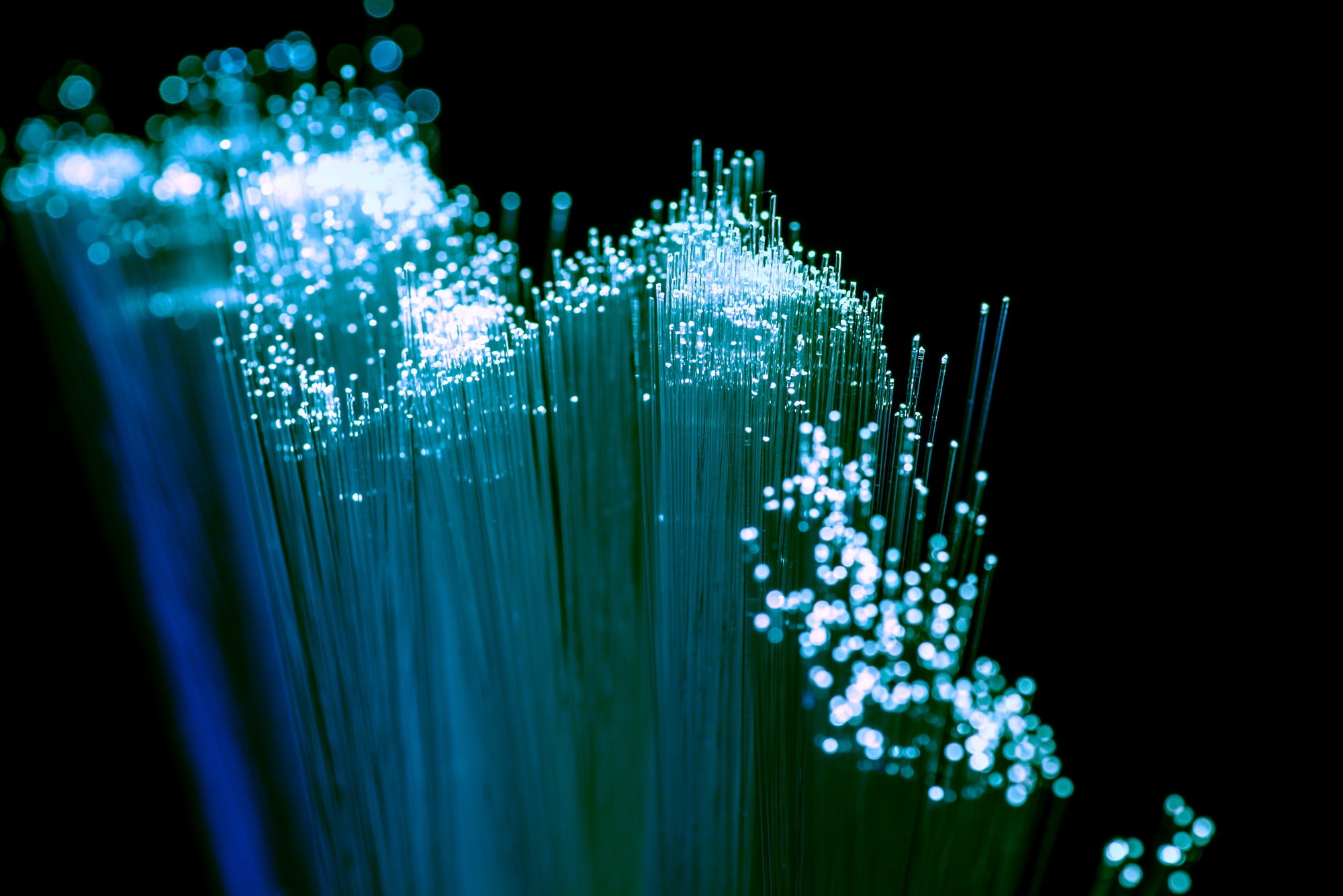 Close up of shiny light blue fiber optics background, communication technology