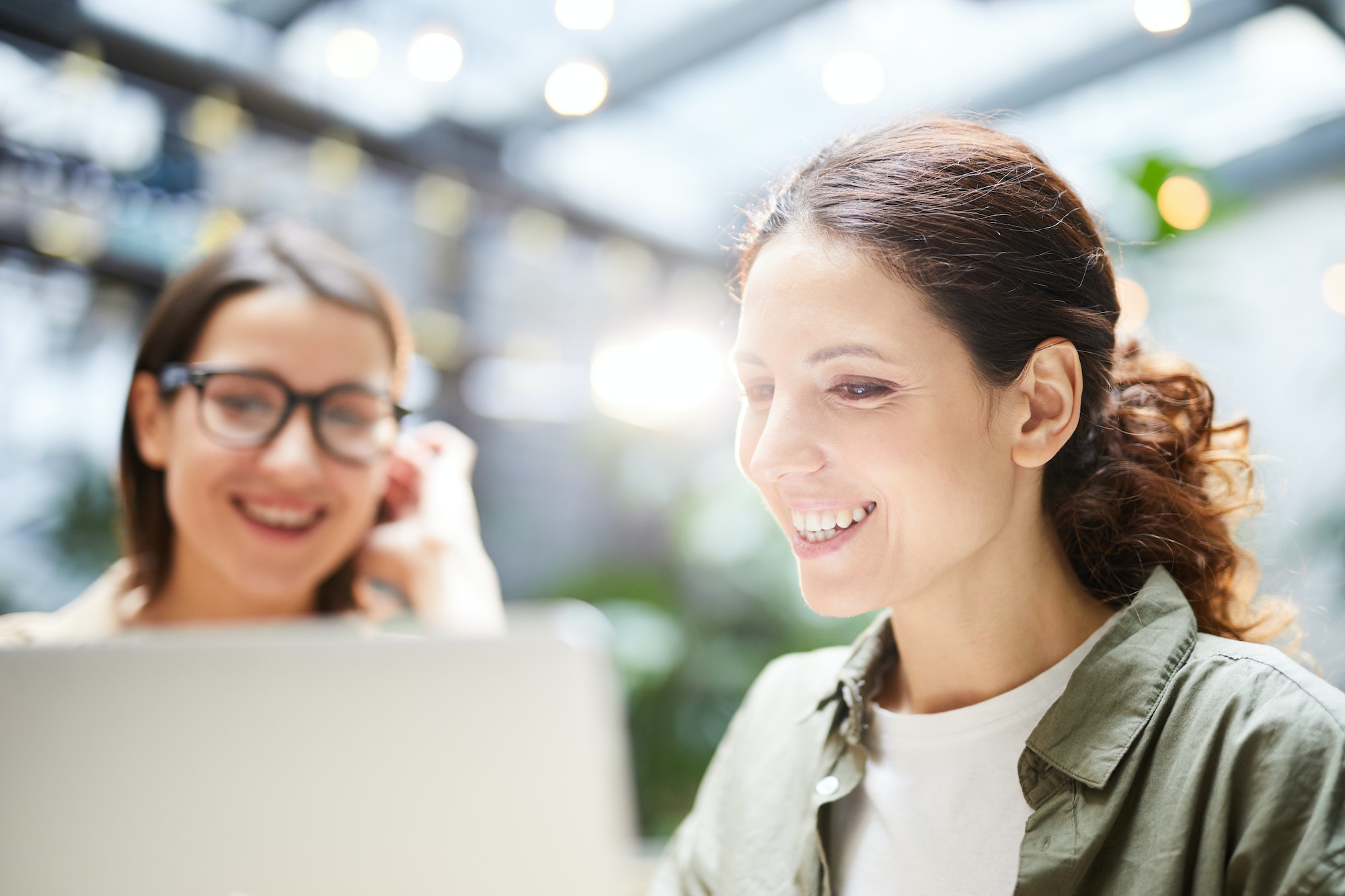 Deux femmes souriantes devant un ordinateur en train de programmer pour développer un site