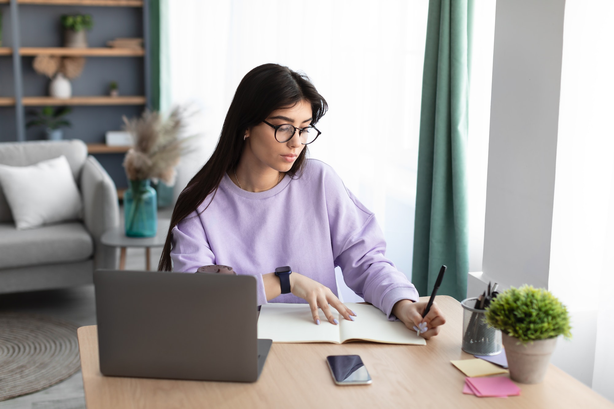 une femme en train de rédiger un article devant un ordinateur