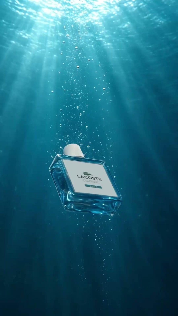Flacon Lacoste Original Aqua immergé sous des rayons de lumière.